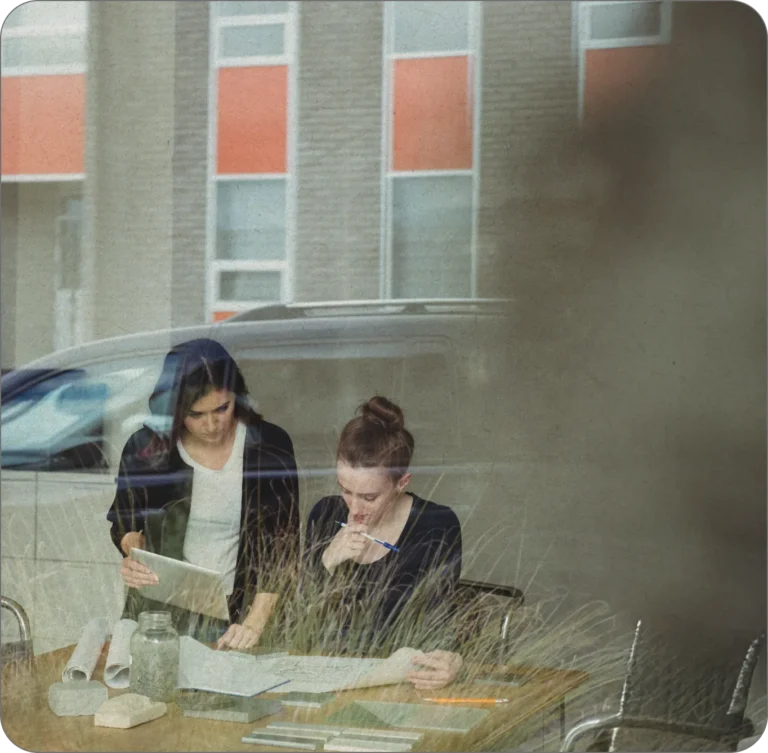 Zwei Frauen arbeiten gemeinsam an Dokumenten.