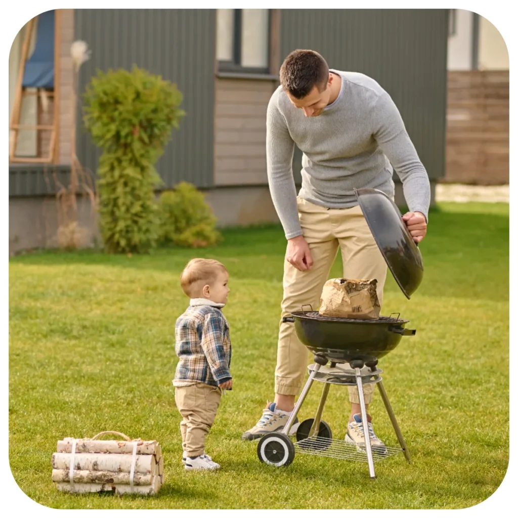 Man and child at outdoor barbecue grill.